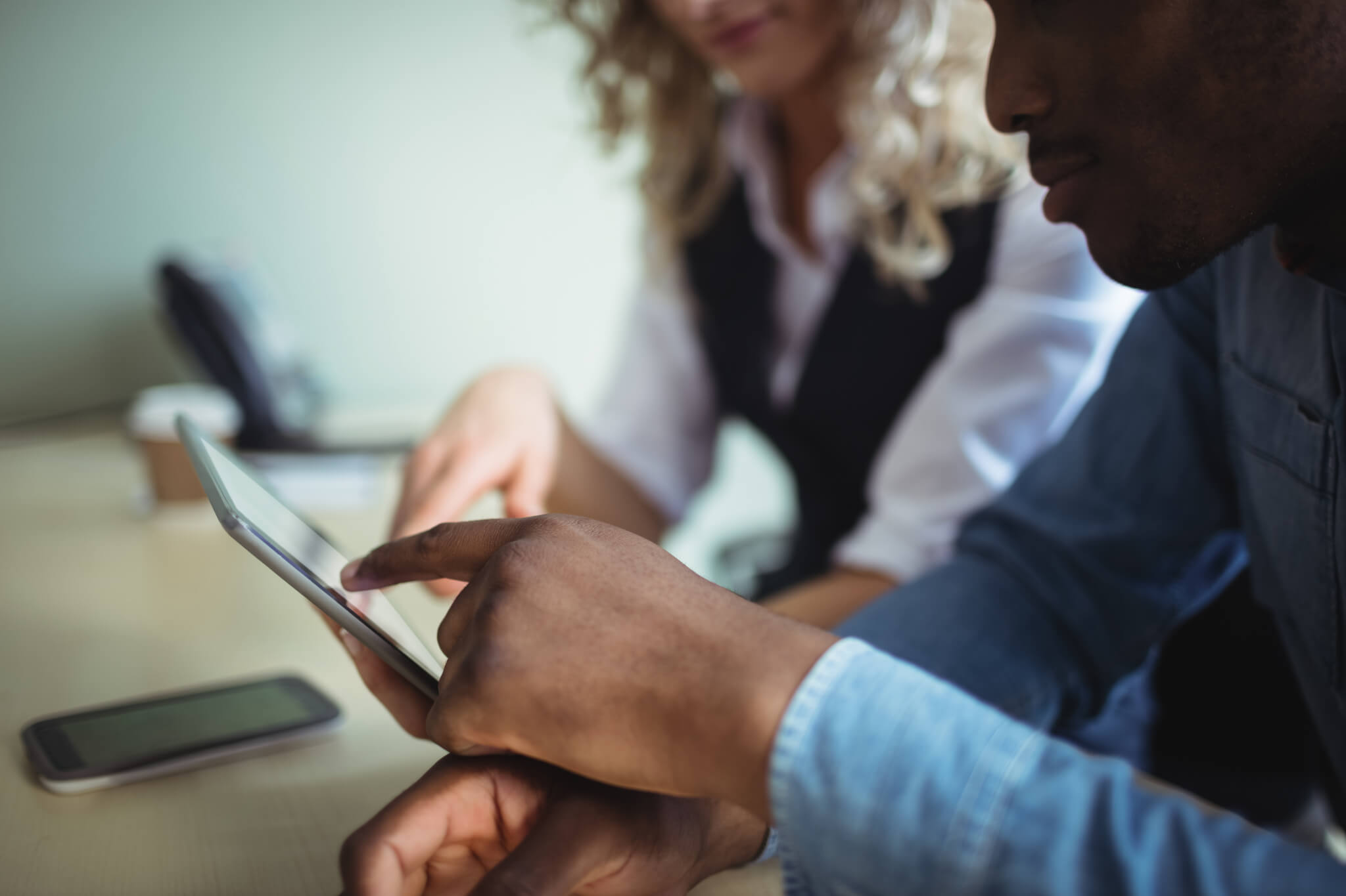 Business executives discussing over digital tablet in office